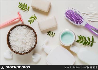 white salt bowl with cosmetics products hairbrush white background