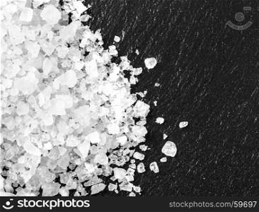 white salt on black background with copy space