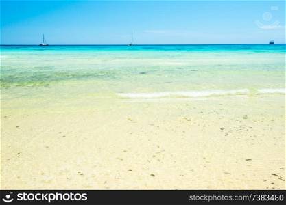 White sand beach and clear sea water under blue sky. Can be used as summer vacation background