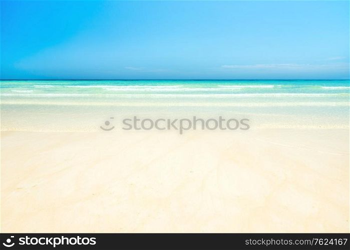 White sand beach and clear sea water under blue sky. Can be used as summer vacation background