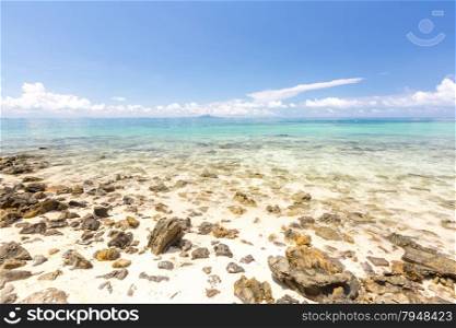 White sand beach and tropical sea with rocky coast