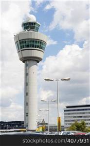 White Schiphol airport control tower against cloudy sky