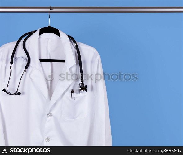 White scrub shirt for medical professional hanging on blue wall