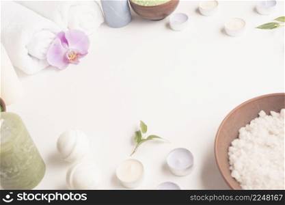 white sea salt candles rolled up towel spa bomb white background