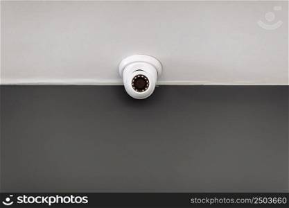 White security CCTV Camera or surveillance operating on ceiling inside room with copy space. High quality photo.. White security CCTV Camera or surveillance operating on ceiling inside room with copy space. High quality photo