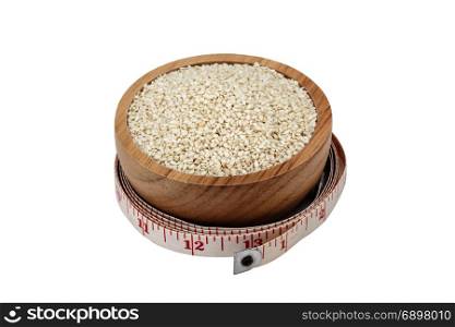 white sesame seeds in wooden bowl with measuring tape isolated on white background with clipping path