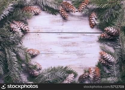 White shabby Christmas border with snow covered pinecones
