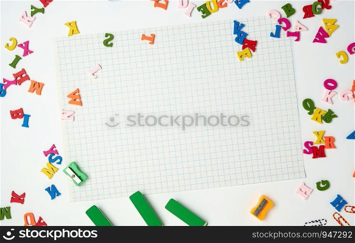white sheets in a cage and small multi-colored wooden letters, back to school, copy space