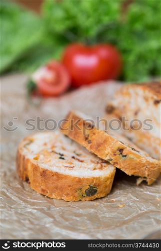 white sliced homemade baguette with dried tomatoes and herbs