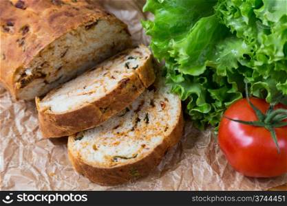 white sliced homemade baguette with dried tomatoes and herbs