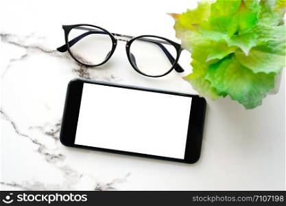White smart phone with blank screen and glasses on white marble table background for mock up, template, technology and lifestyle concept