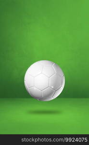White soccer ball isolated on a green studio background. 3D illustration . White soccer ball on a green studio background
