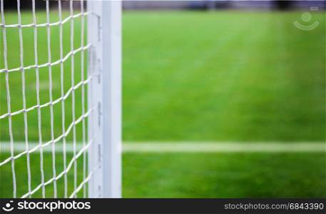 White soccer nets, soccer. Grass on football playground in the background. Blurred concept