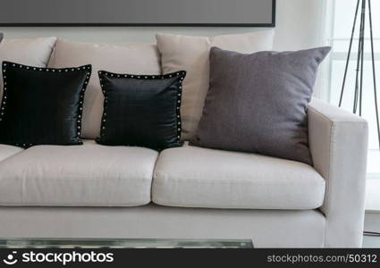 white sofa with black and grey pillows in living room interior