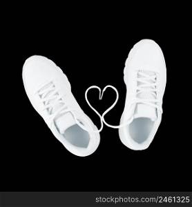 White sport shoes and heart shape from laces isolated on a black background.. White sport shoes and heart shape from laces isolated on black background.