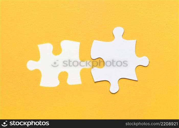 white stamp puzzle piece with cardboard puzzle piece yellow surface