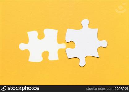 white stamp puzzle piece with cardboard puzzle piece yellow surface