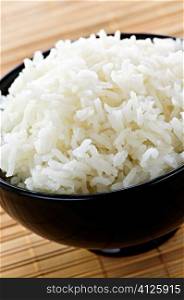 White steamed rice in black round bowl