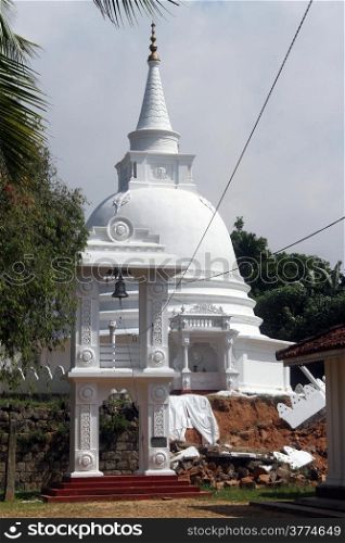 White stupa and bell tower in Sapugoda viharaya in Beruwala, Sri Lanka