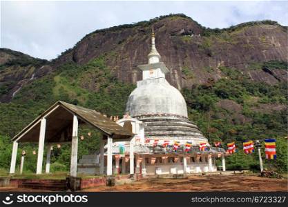 White stupa and flags under Adam&rsquo;s Peak in Sri Lanka