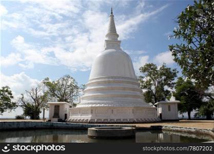 White stupa, pool and magnolia in monastery, Sri Lanka