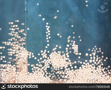 White styrofoam balls on tank. Flying balls in transparent container.