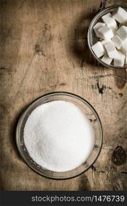 White sugar . On the wooden background. Top view. White sugar . On wooden background.