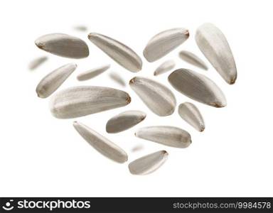 White sunflower seeds in the shape of a heart on a white background.. White sunflower seeds in the shape of a heart on a white background