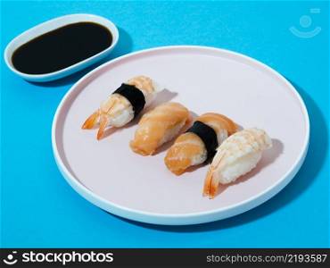 white sushi plate soy sauce bowl blue background