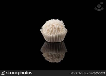 White sweet chocolate, covered the coconut shaving on a dark background