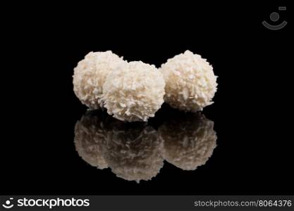 White sweet chocolate, covered the coconut shaving on a dark background