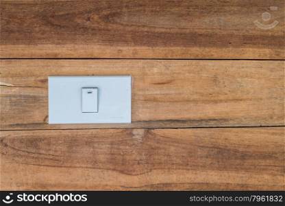White switch for light on wooden wall