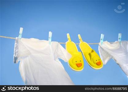 White t-shirts and slippers on the clothesline on a sunny day