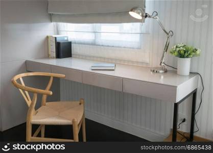 white table with wooden chair and books in modern working area at home