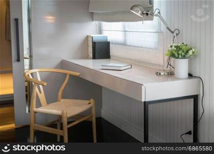 white table with wooden chair and books in modern working area at home