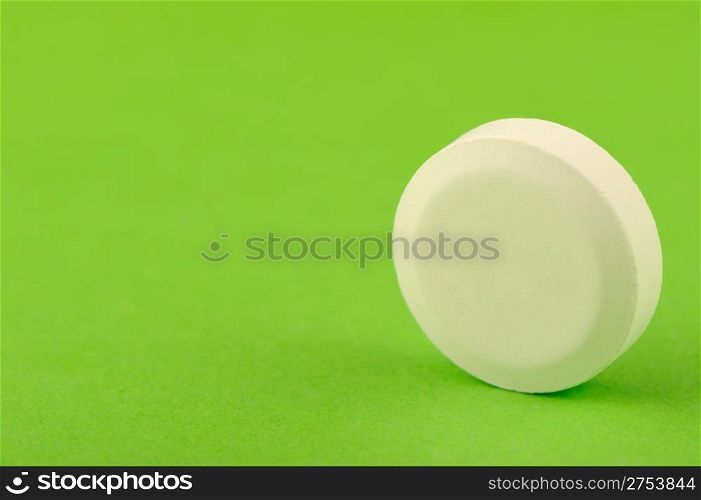 White tablet on a green background. A photo close up
