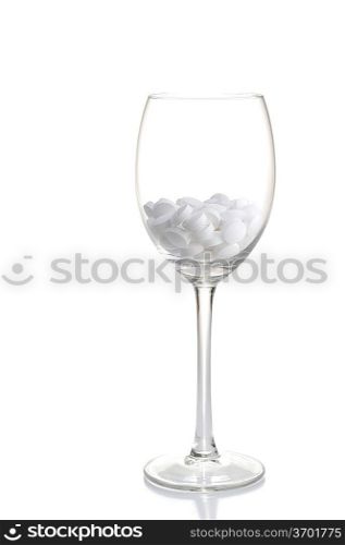 white tablets lie in glass for wine