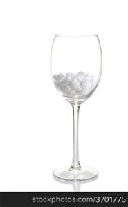 white tablets lie in glass for wine