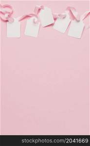 white tags pink ribbon top background with space text