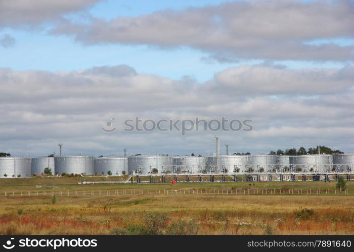 white tanks in tank farm with clouds in sky