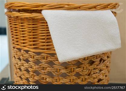 white terry towel in a wicker basket in the hotel bathroom. towel in the bathroom