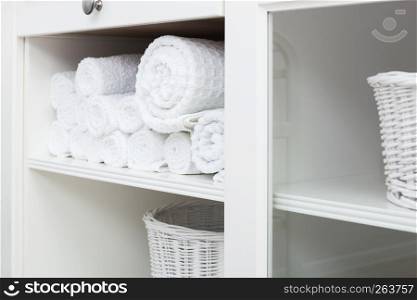 white towel on a shelf in the closet