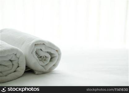 white towel on bed with see through curtain background. hotel bedroom interior