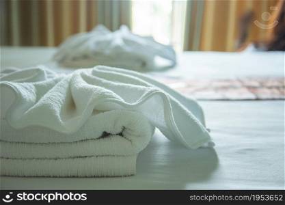 white towels on the bed with light from window.