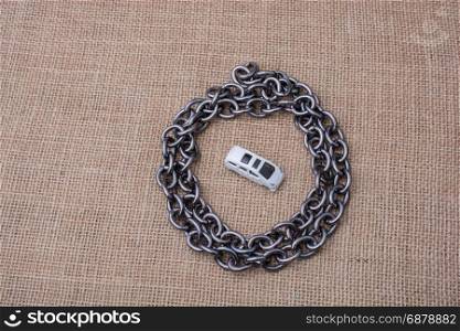 White toy car in a round chain circle on a canvas background