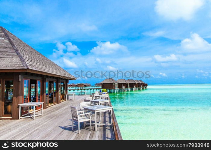 White tropical beach in Maldives with few palm trees and blue lagoon