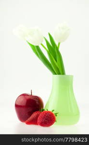 white tulips in a vase apple and strawberry isolated on white