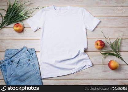 White unisex cotton T-shirt mockup with green grass and apples. Design t shirt template, tee print presentation mock up