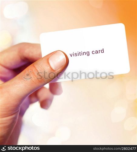 White visit card in hand on bright background