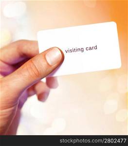 White visit card in hand on bright background